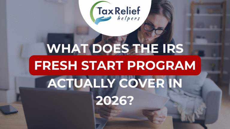 A couple completing their taxes at a desk in front of a laptop.