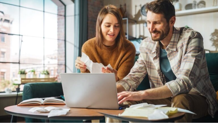 A couple doing their taxes in the kitchen.